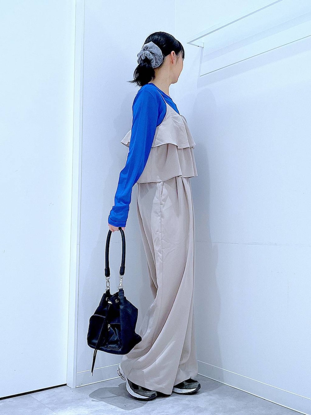 ベージュ系のサロペット/オーバーオール、ブラック系のショルダーバッグ、グレー系のシュシュを着用したレディースの春コーディネートの4枚目の写真