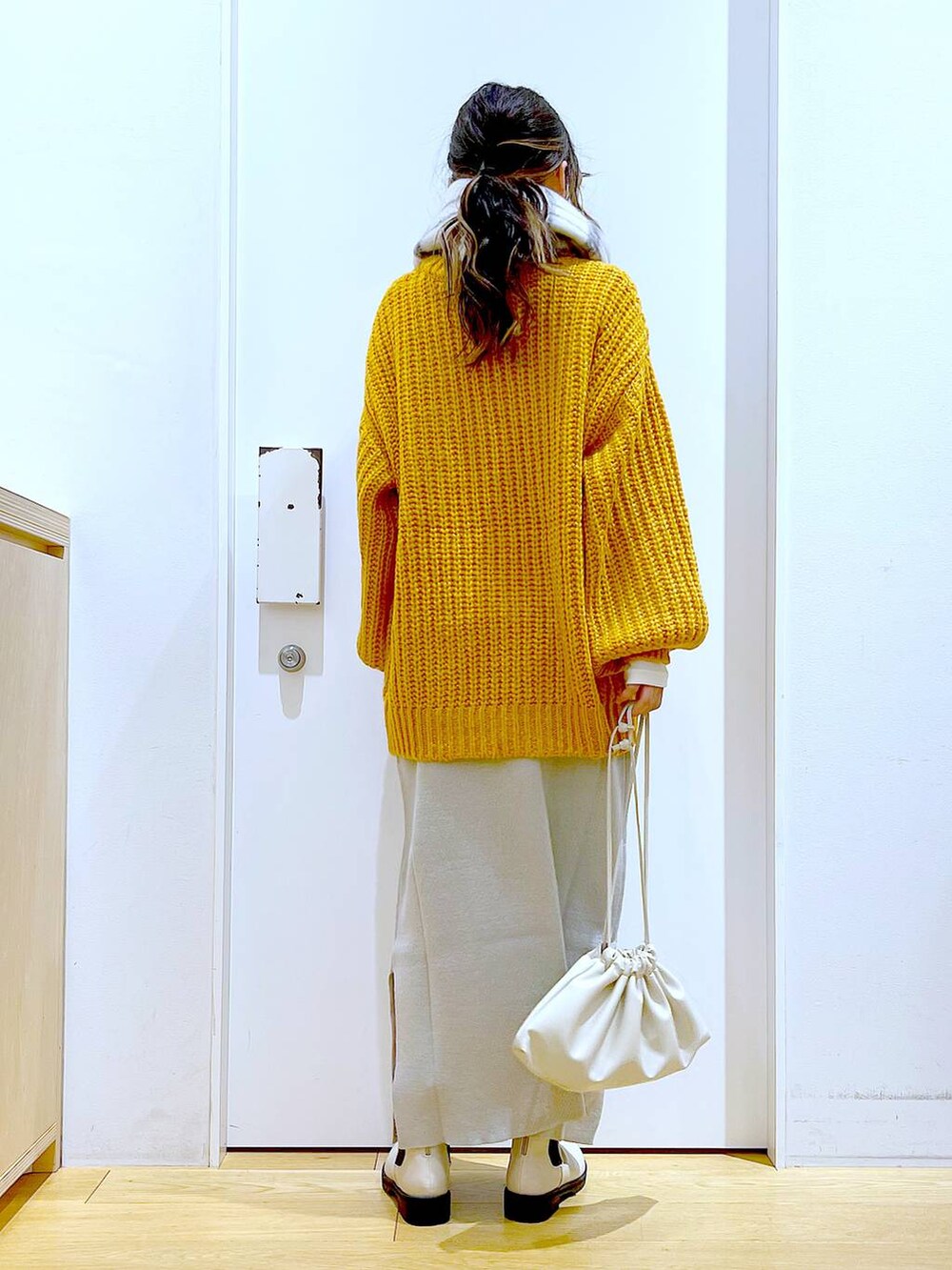 グレー系のスカート、ベージュ系のブーツ、ベージュ系のショルダーバッグを着用したレディースの冬コーディネートの5枚目の写真