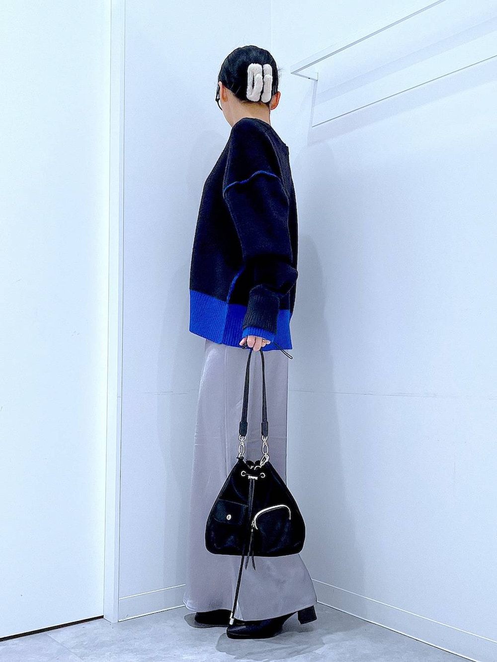 ブラック系のショルダーバッグ、ブラック系のブーツ、ブラック系のニット/セーターを着用したレディースの冬コーディネートの3枚目の写真