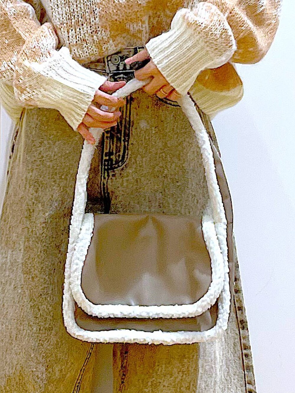 ブラック系のブーツ、ベージュ系のショルダーバッグ、ベージュ系のデニムパンツを着用したレディースの冬コーディネートの9枚目の写真