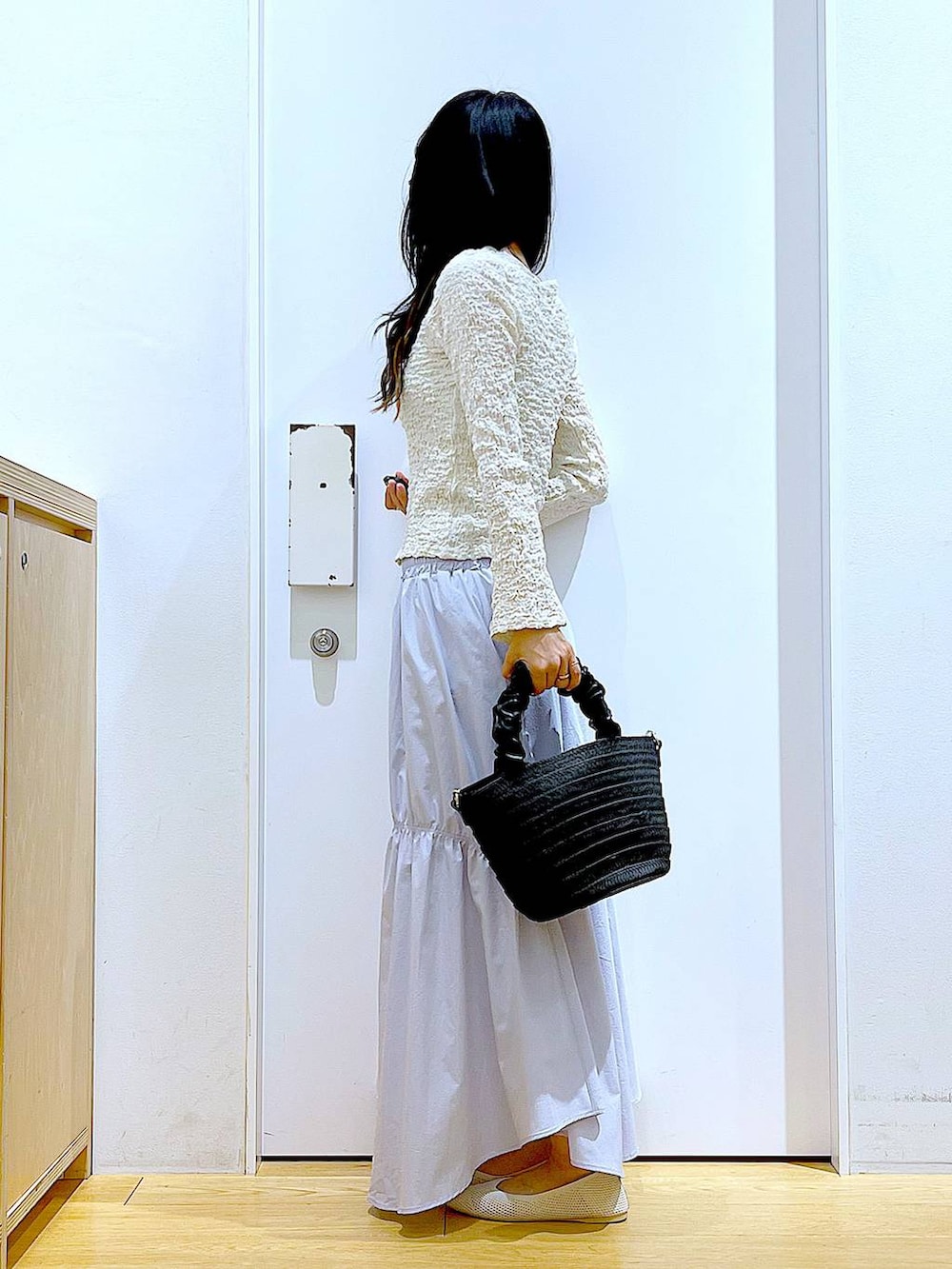 ホワイト系のカーディガン/ボレロ、イエロー系のニット/セーター、ホワイト系のパンプスを着用したレディースの春コーディネートの3枚目の写真