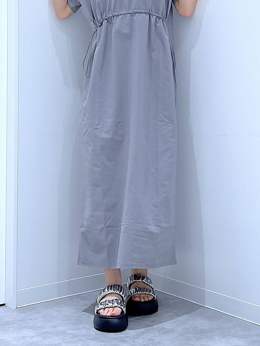 シルバー系のサンダル、グレー系のワンピース、ホワイト系のトートバッグを着用したレディースの夏コーディネートの8枚目の写真