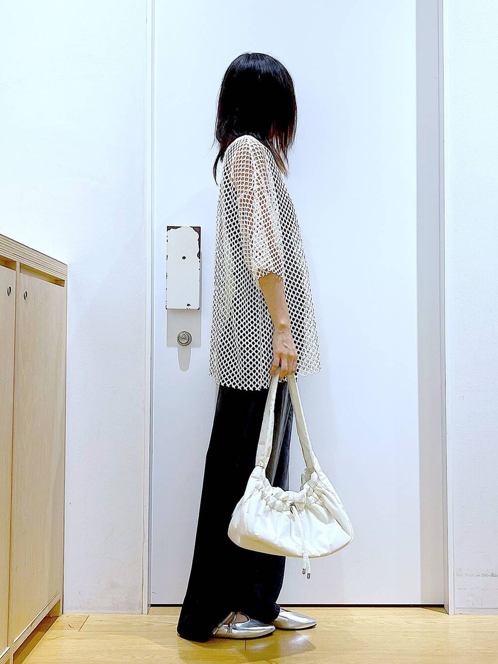 ホワイト系のハンドバッグ、ブラック系のニット/セーター、ホワイト系のTシャツ/カットソーを着用したレディースの夏コーディネートの4枚目の写真