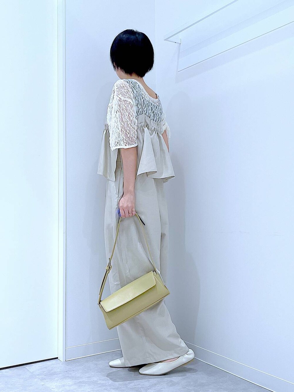 ホワイト系のパンプス、イエロー系のショルダーバッグ、ホワイト系のTシャツ/カットソーを着用したレディースの夏コーディネートの3枚目の写真