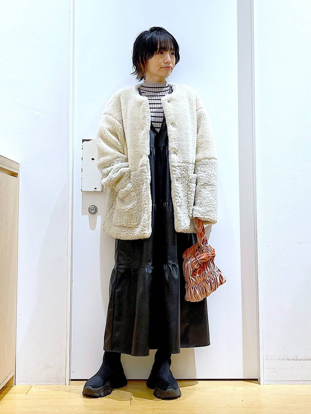 その他のニット/セーター、ピンク系のショルダーバッグ、ブラック系のブーツを着用したレディースの冬コーディネートの2枚目の写真