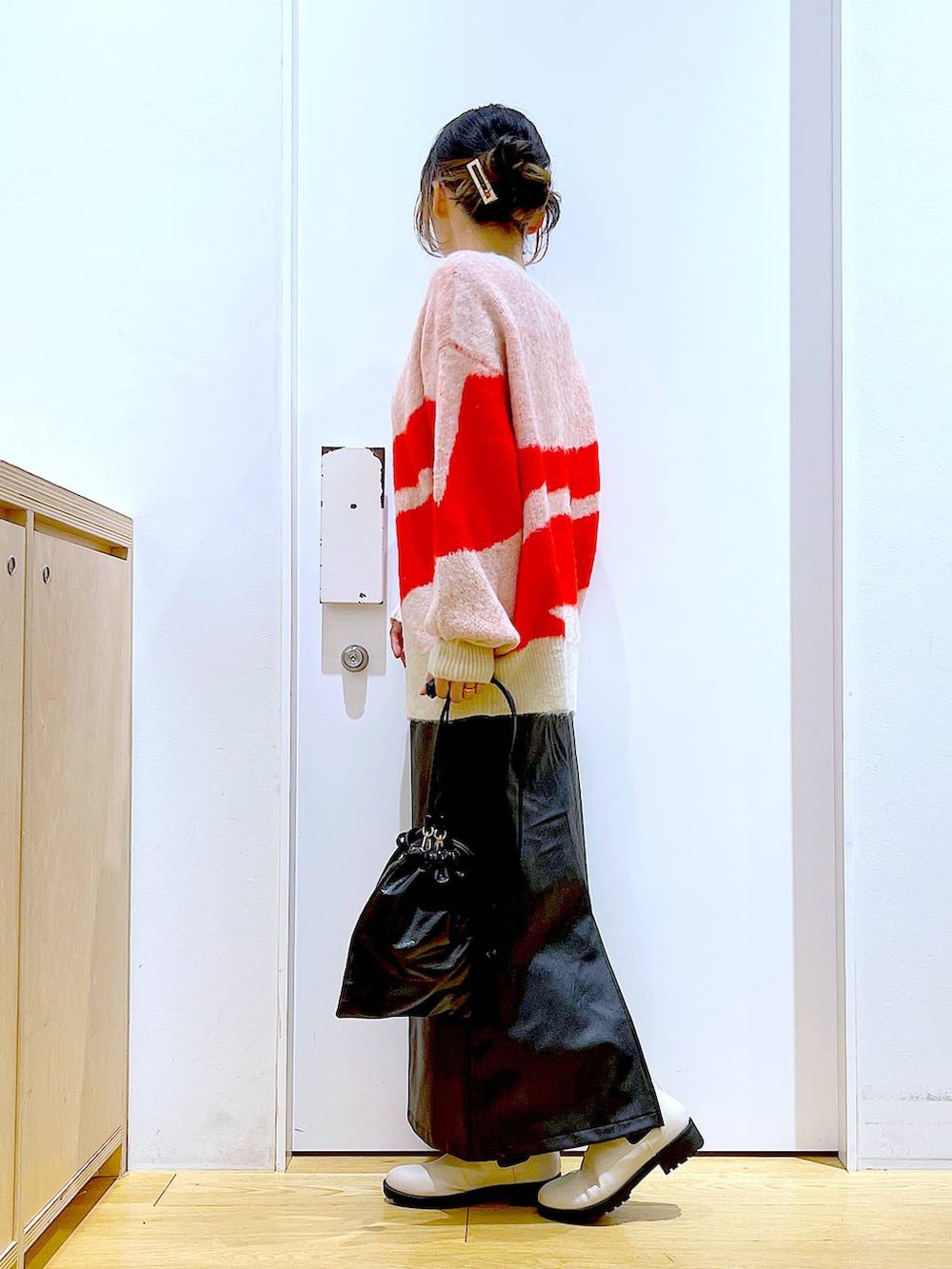 ベージュ系のブーツ、ブラック系のスカート、ブラック系のショルダーバッグを着用したレディースの冬コーディネートの3枚目の写真