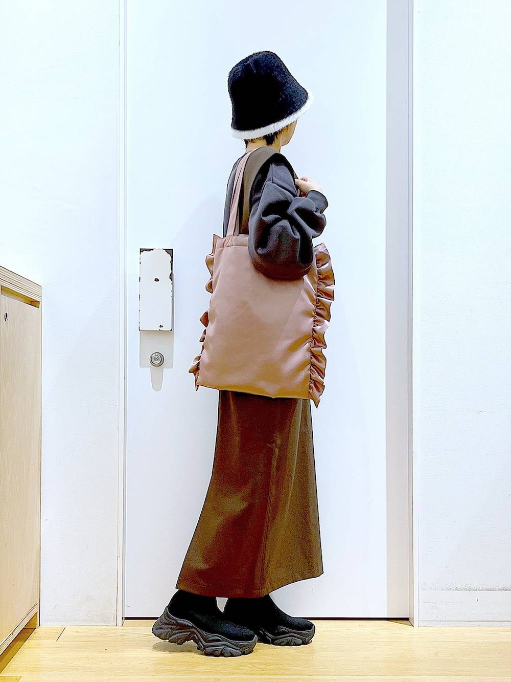 ブラック系のブーツ、ブラウン系のサロペット/オーバーオール、ピンク系のトートバッグを着用したレディースの冬コーディネートの4枚目の写真