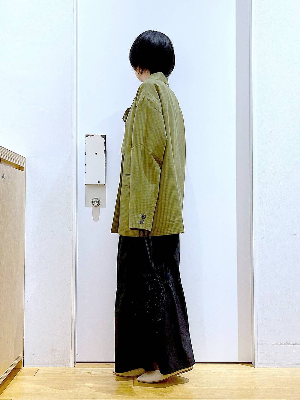 ブラック系のショルダーバッグ、ホワイト系のパンプス、ホワイト系のTシャツ/カットソーを着用したレディースの秋コーディネートの3枚目の写真