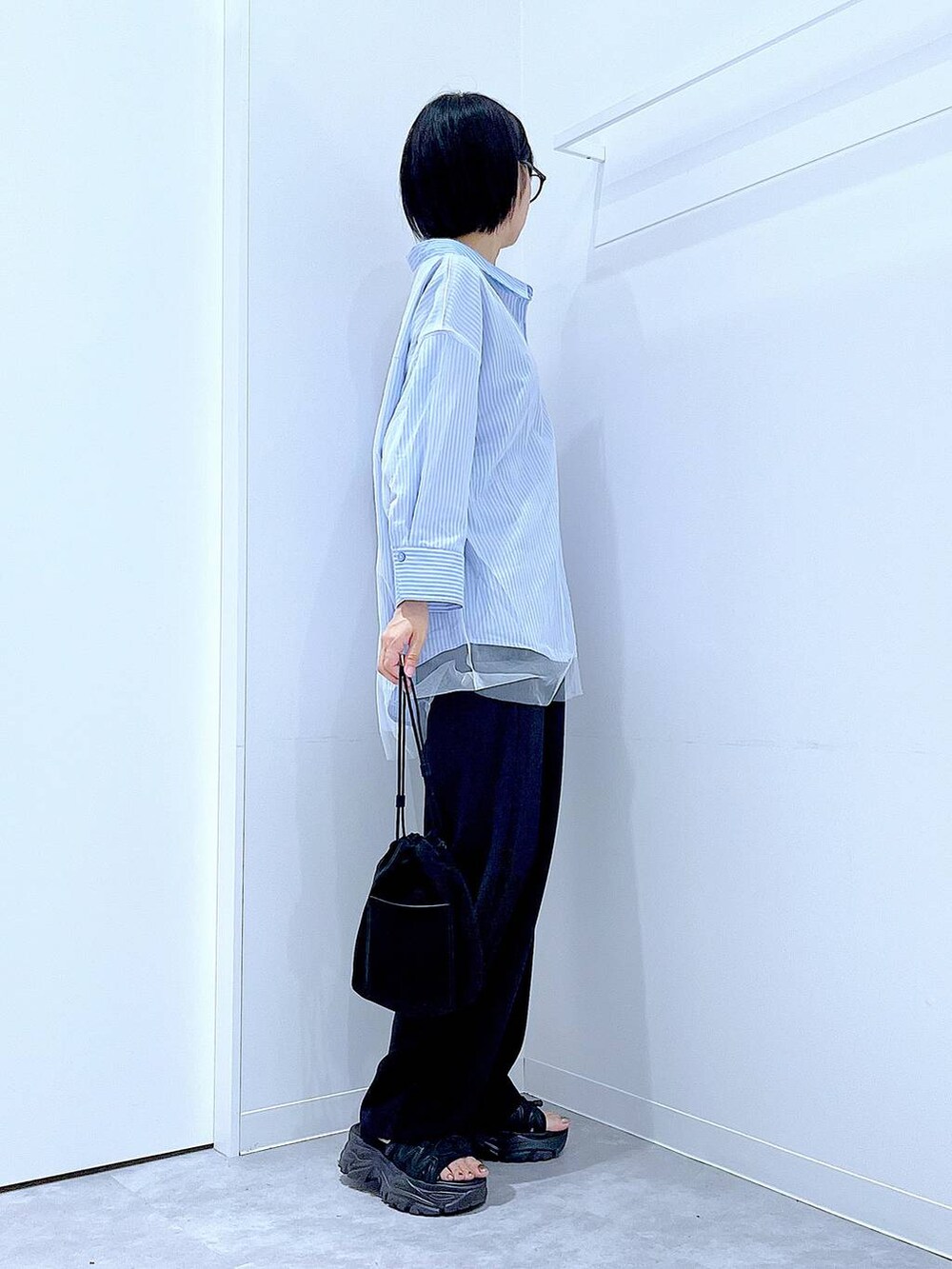 ブラック系のショルダーバッグ、ブラック系のその他パンツ、ブルー系のシャツ/ブラウスを着用したレディースの秋コーディネートの4枚目の写真