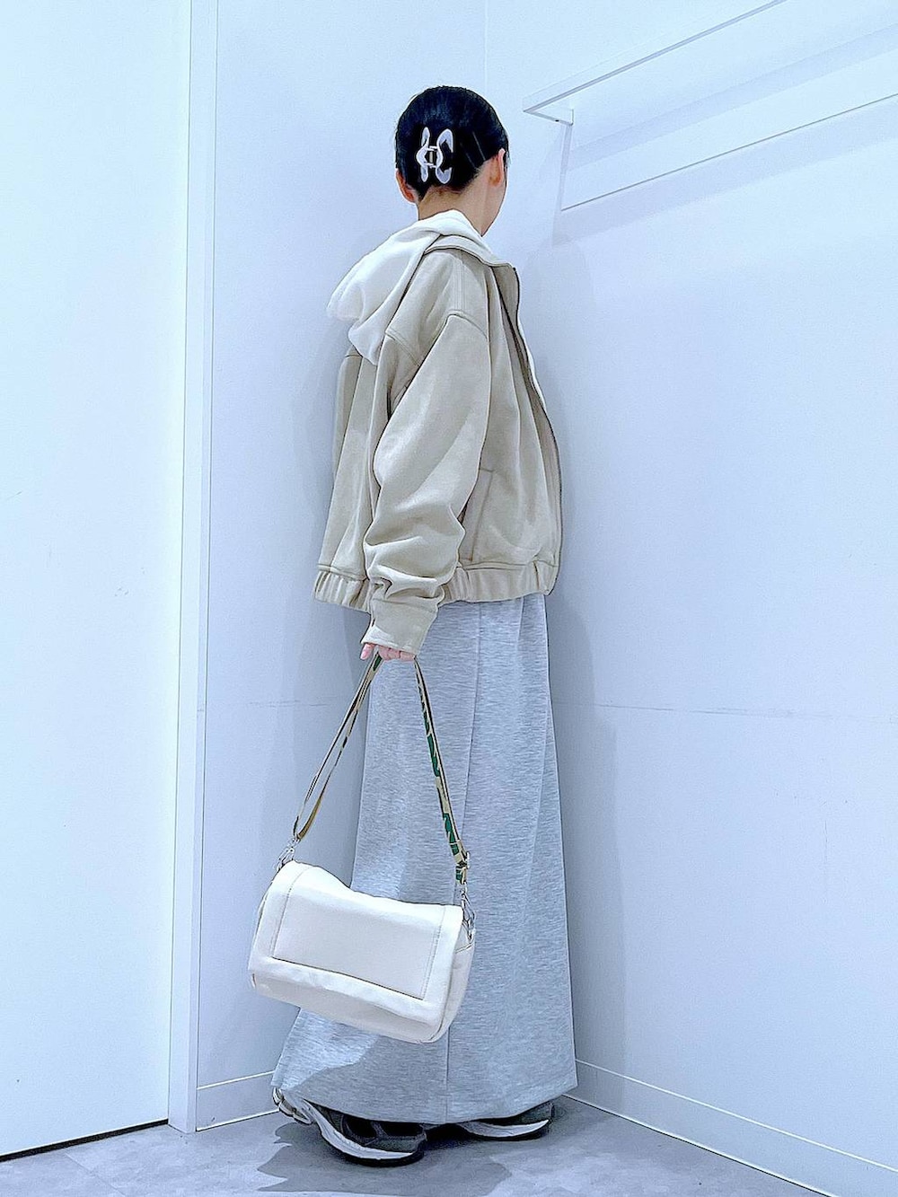 ホワイト系のショルダーバッグ、ベージュ系のニット/セーター、グレー系のスカートを着用したレディースの春コーディネートの4枚目の写真