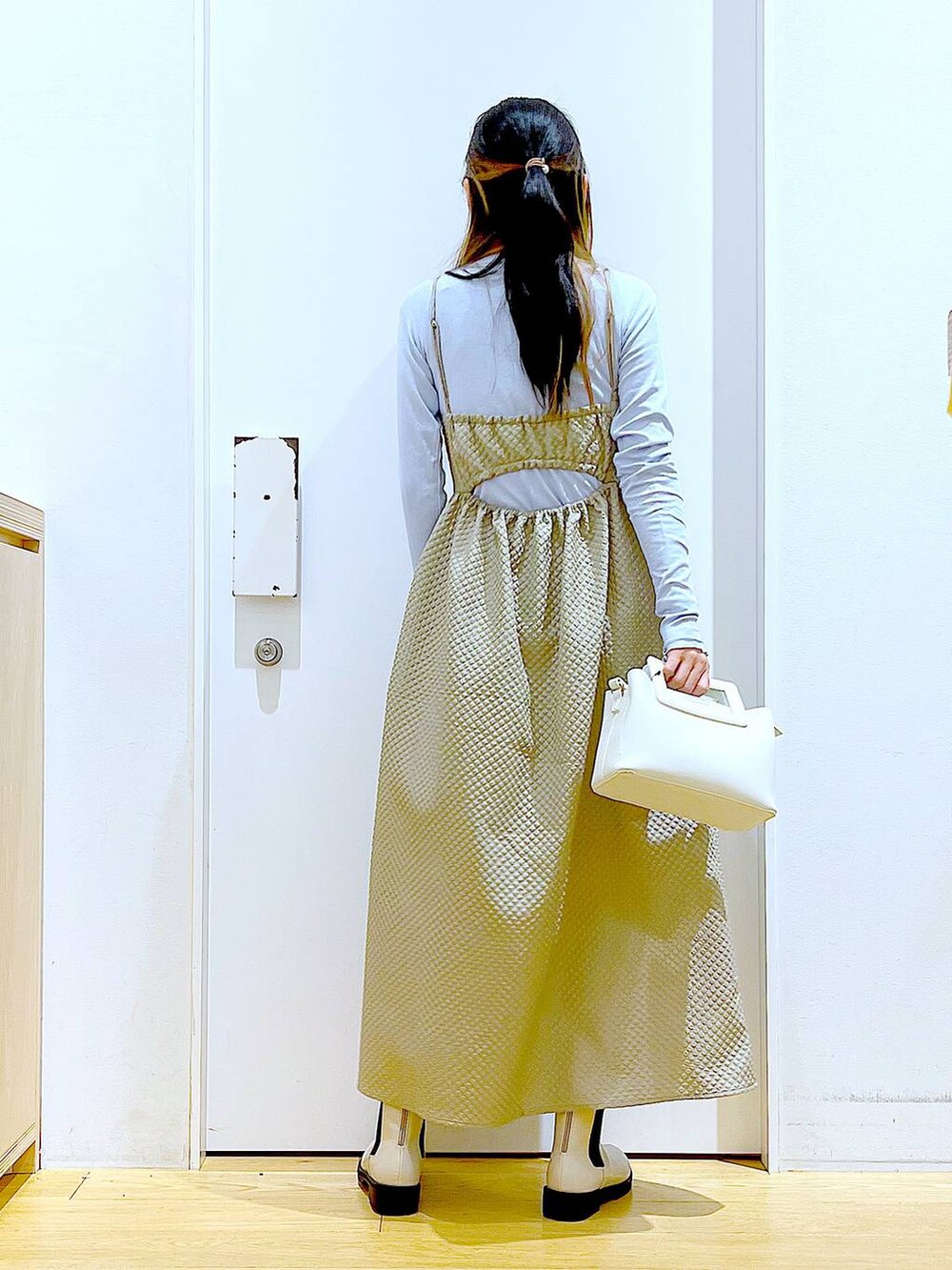 ブルー系のTシャツ/カットソー、ブラウン系のワンピース、ベージュ系のブーツを着用したレディースの冬コーディネートの5枚目の写真