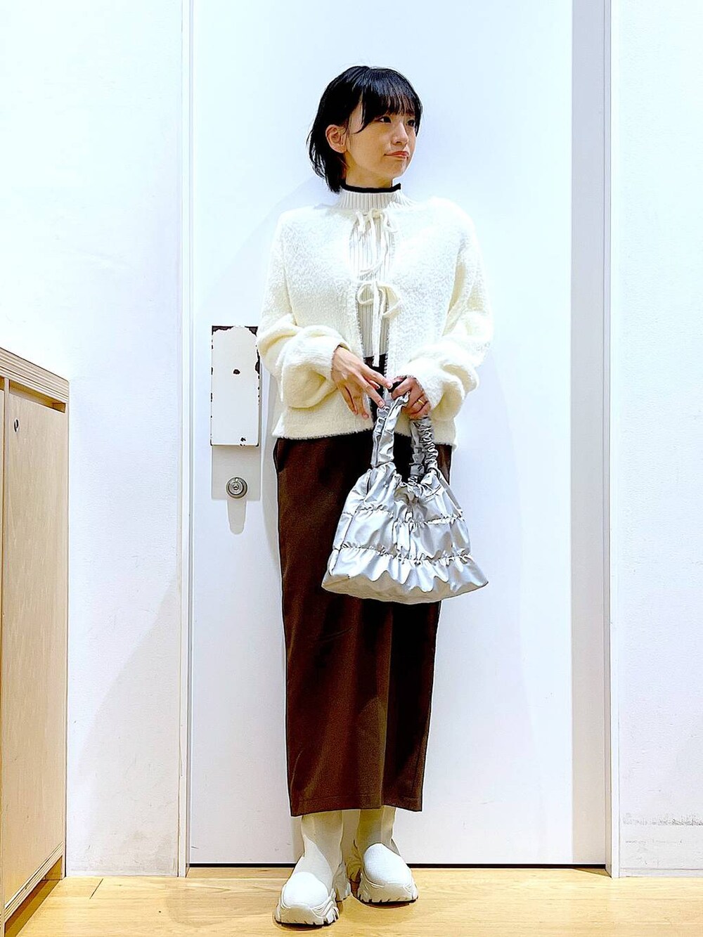 ベージュ系のニット/セーター、ベージュ系のブーツ、ブラウン系のサロペット/オーバーオールを着用したレディースの冬コーディネートの2枚目の写真