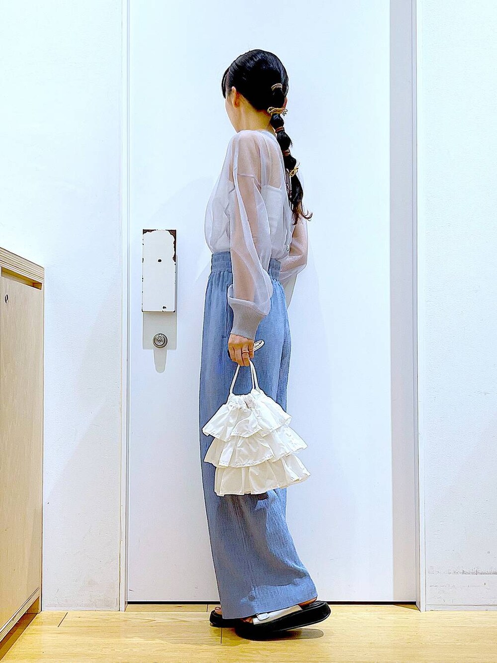 ホワイト系のショルダーバッグ、シルバー系のサンダル、グレー系のカーディガン/ボレロを着用したレディースの春コーディネートの3枚目の写真