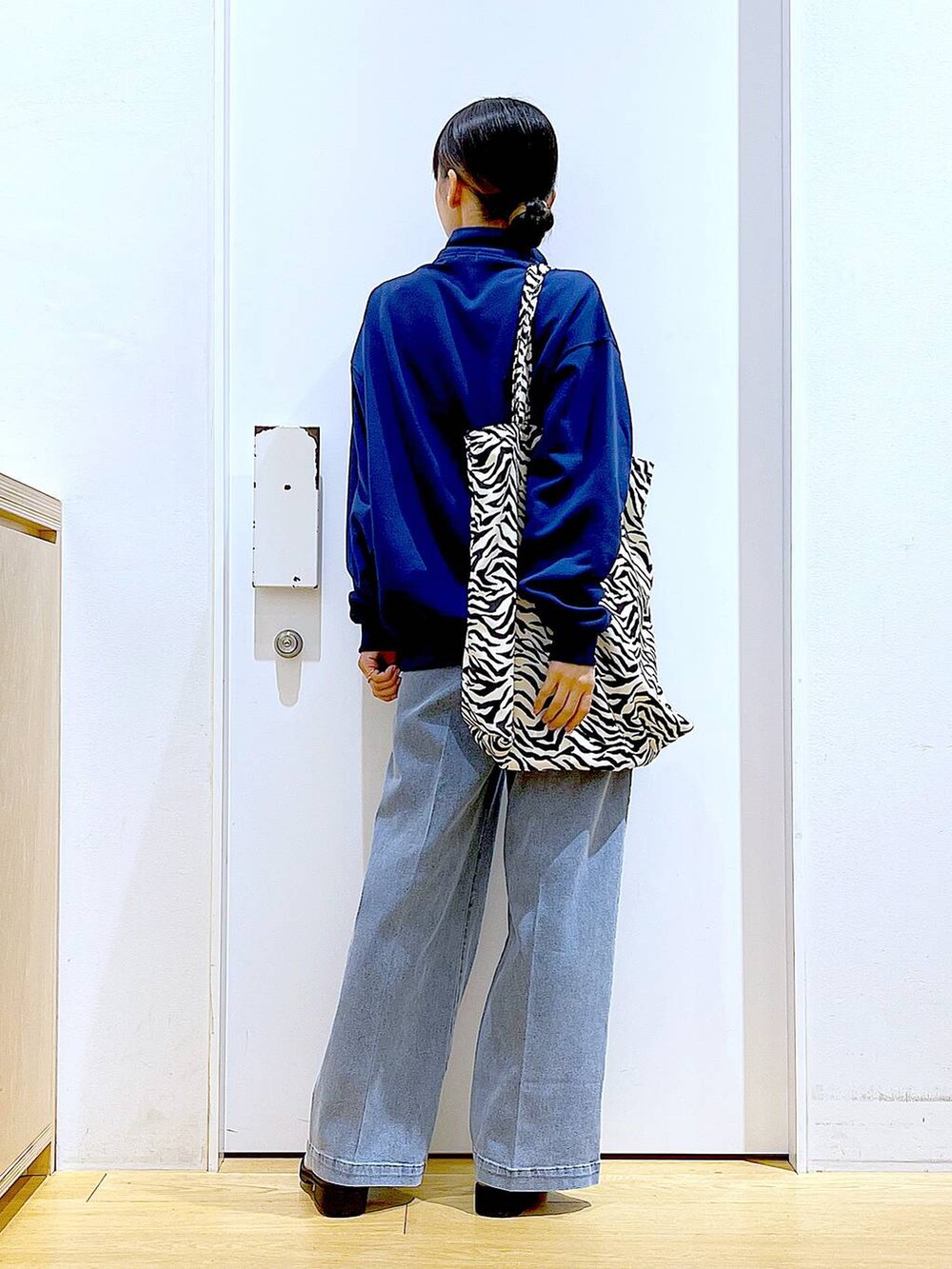 ブルー系のデニムパンツ、ブルー系のスウェット、ベージュ系のブーツを着用したレディースの春コーディネートの5枚目の写真