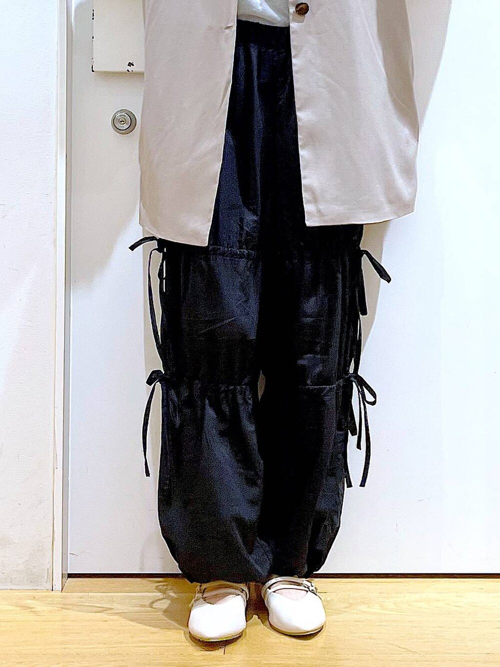 ブラック系のショルダーバッグ、ホワイト系のパンプス、ブラック系のその他パンツを着用したレディースの秋コーディネートの8枚目の写真