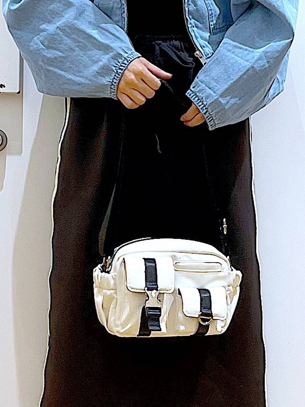 ブルー系のデニムジャケット、ブラック系のスカート、ブラック系のスニーカーを着用したレディースの春コーディネートの9枚目の写真