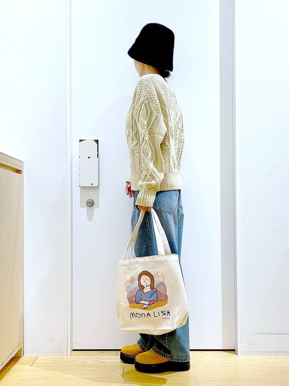 その他のトートバッグ、ブルー系のデニムパンツ、ベージュ系のブーツを着用したレディースの冬コーディネートの3枚目の写真