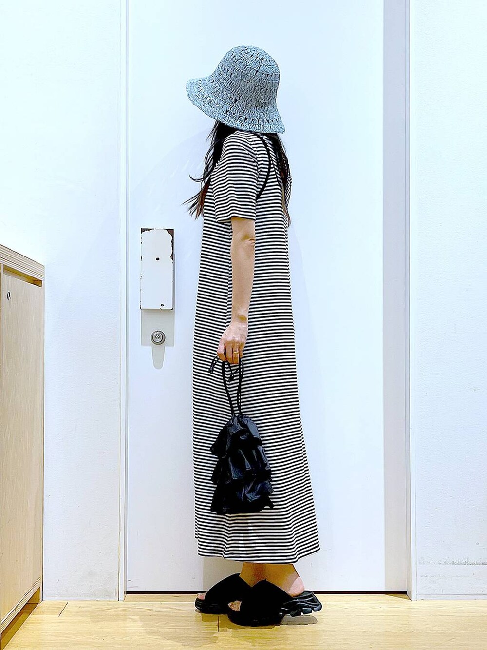 ブラック系のショルダーバッグ、ブラック系のサンダル、ブラック系のワンピースを着用したレディースの夏コーディネートの3枚目の写真