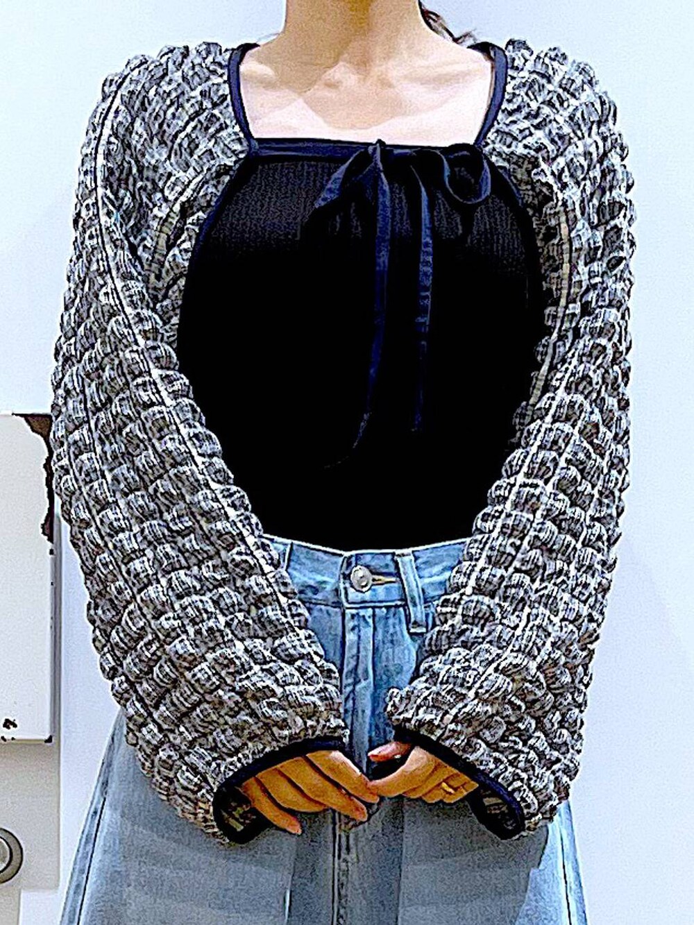 ブルー系のデニムパンツ、ブラック系のTシャツ/カットソー、ベージュ系のショルダーバッグを着用したレディースの夏コーディネートの7枚目の写真