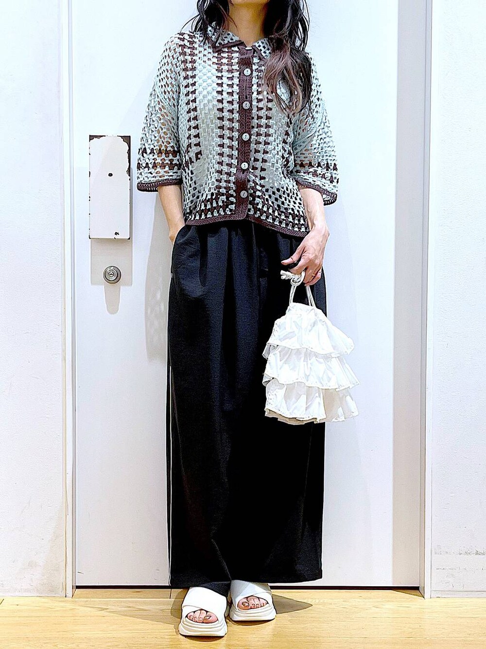 ホワイト系のショルダーバッグ、ホワイト系のサンダル、グリーン系のカーディガン/ボレロを着用したレディースの春コーディネートの6枚目の写真