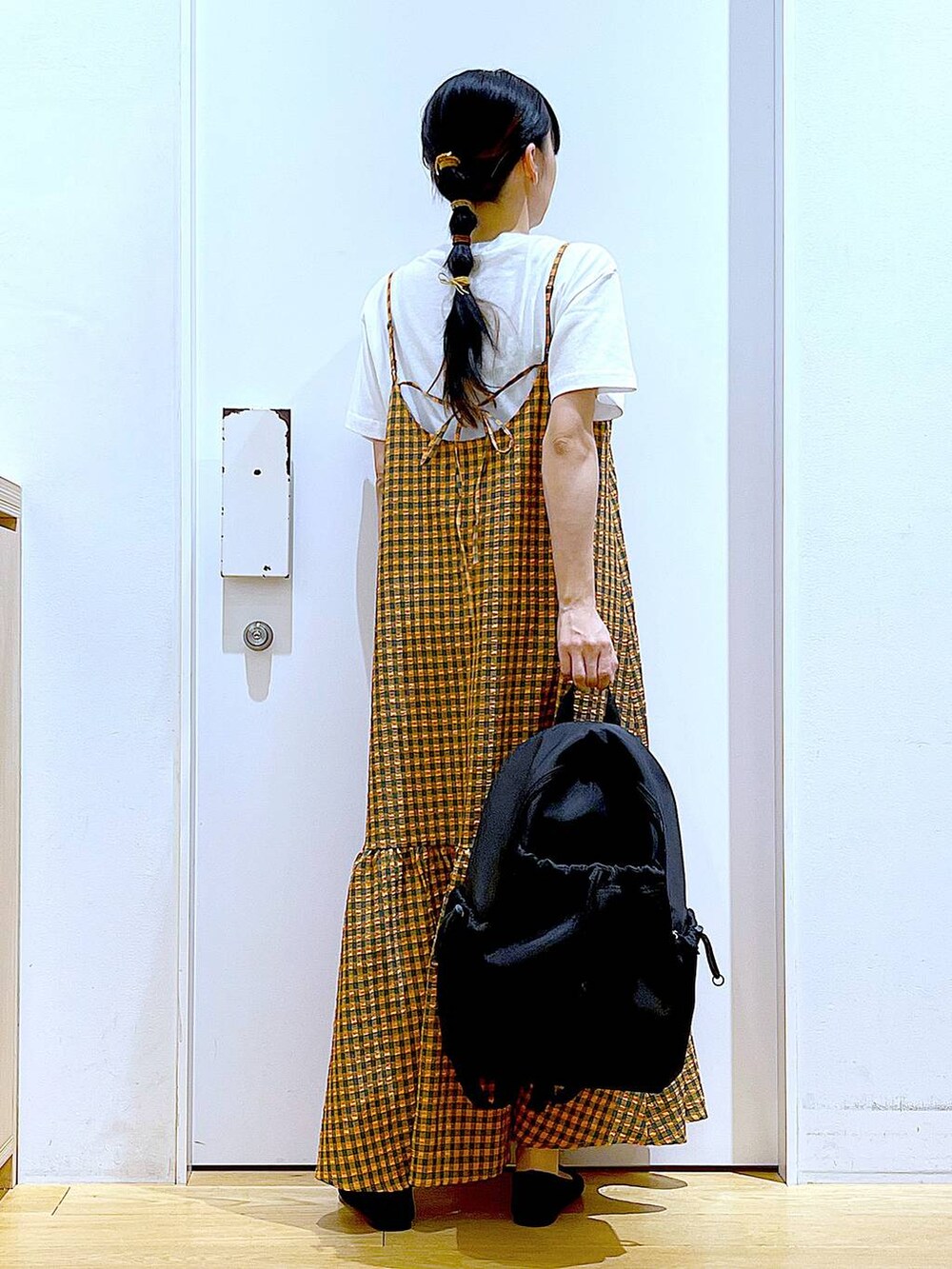 オレンジ系のワンピース、ブラック系のバックパック/リュック、ブラック系のパンプスを着用したレディースの春コーディネートの5枚目の写真