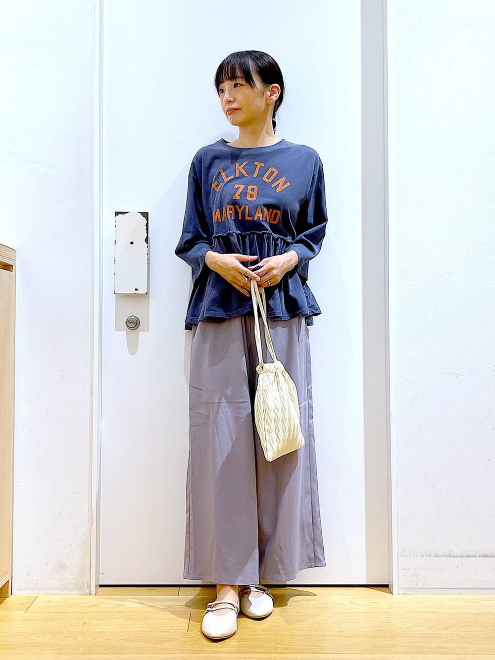 ホワイト系のショルダーバッグ、グレー系のその他パンツ、ホワイト系のパンプスを着用したレディースの秋コーディネートの2枚目の写真