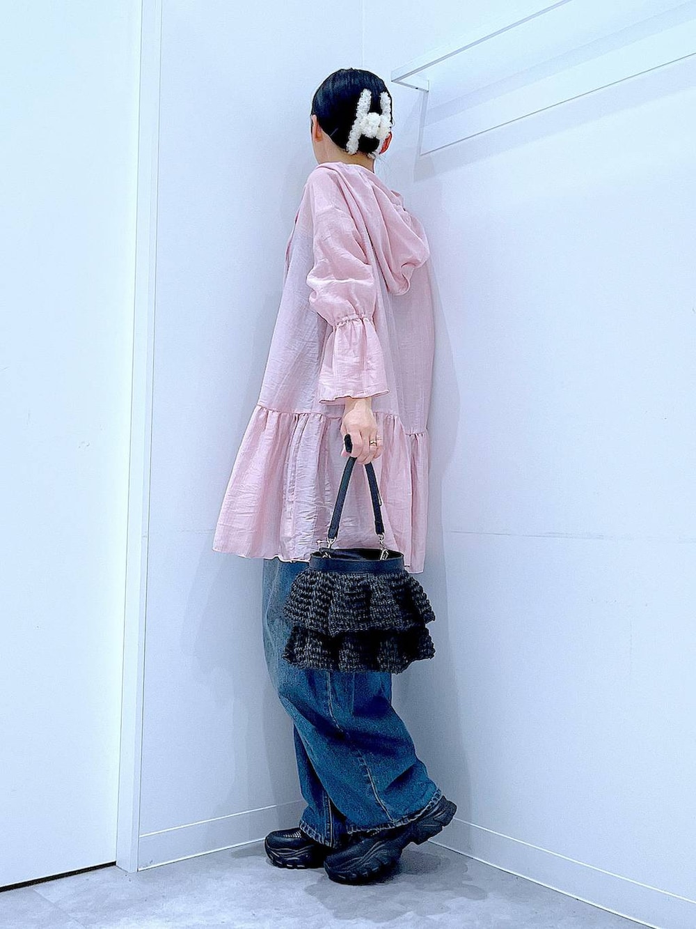 ブルー系のデニムパンツ、ブラック系のスニーカー、ブラック系のショルダーバッグを着用したレディースの春コーディネートの3枚目の写真
