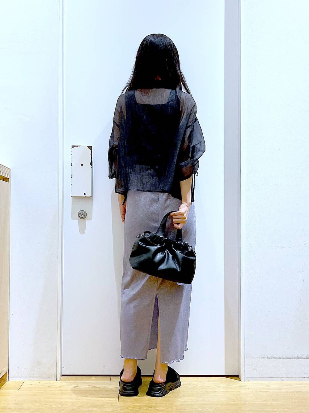 パープル系のスカート、ブラック系のサンダル、ブラック系のニット/セーターを着用したレディースの夏コーディネートの5枚目の写真