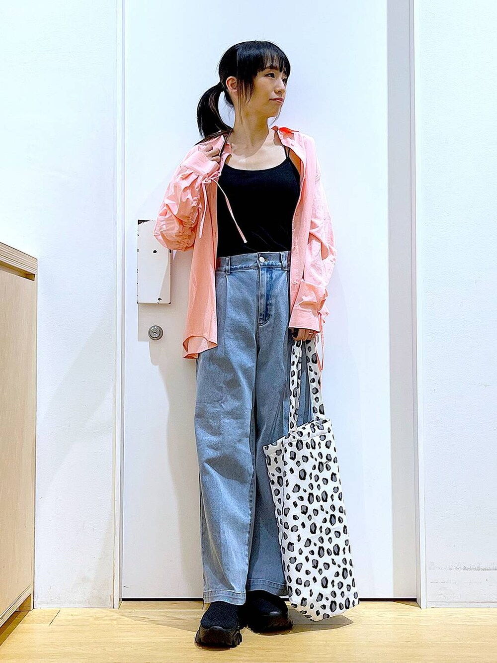 ブルー系のデニムパンツ、ホワイト系のトートバッグ、ピンク系のシャツ/ブラウスを着用したレディースの春コーディネートの2枚目の写真