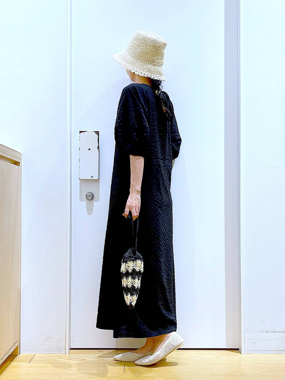 ホワイト系のパンプス、ブラック系のショルダーバッグ、ブラック系のワンピースを着用したレディースの夏コーディネートの4枚目の写真