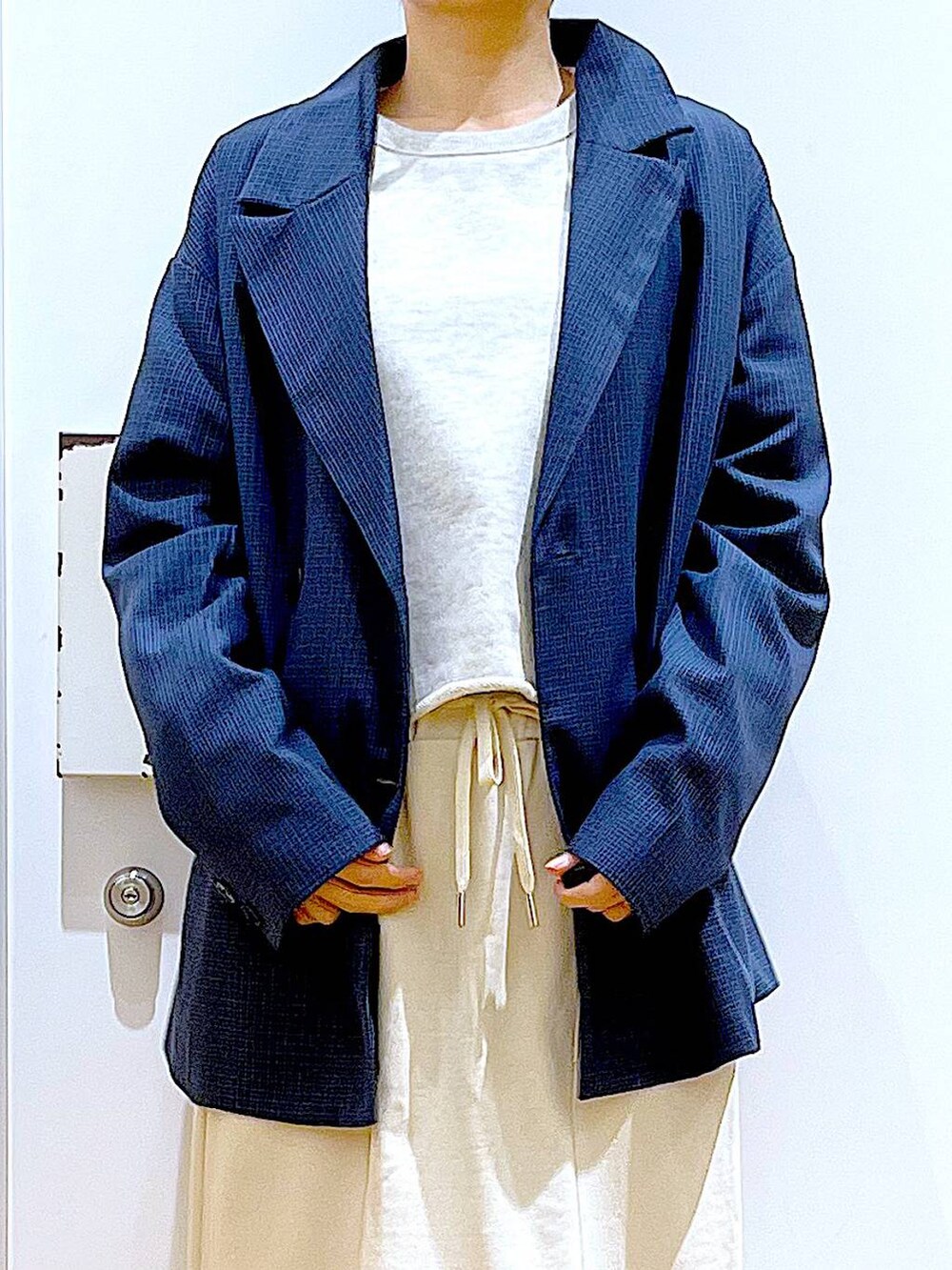 シルバー系のローファー、シルバー系のショルダーバッグ、ベージュ系のスウェットを着用したレディースの春コーディネートの7枚目の写真