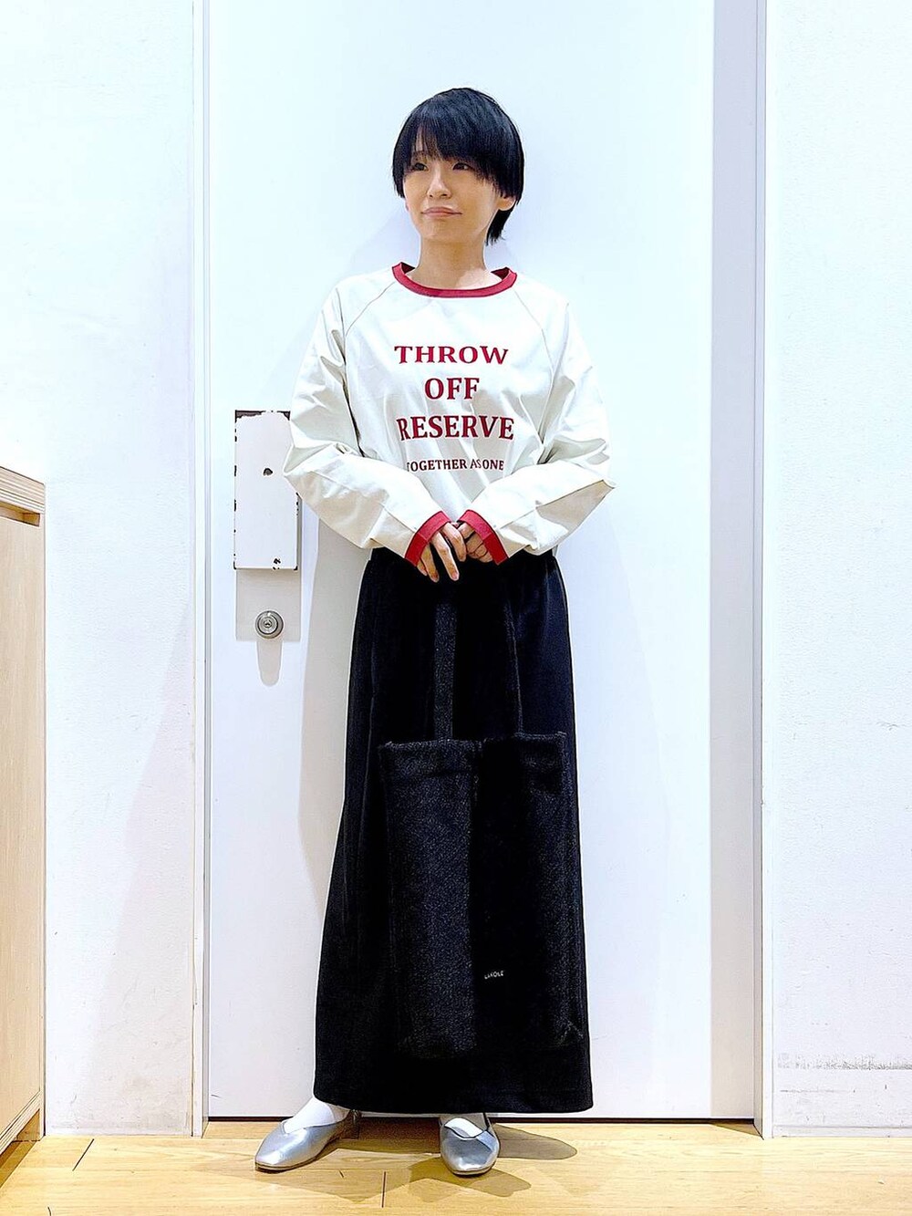 ブラック系のトートバッグ、シルバー系のパンプス、ブラック系のスカートを着用したレディースの春コーディネートの2枚目の写真