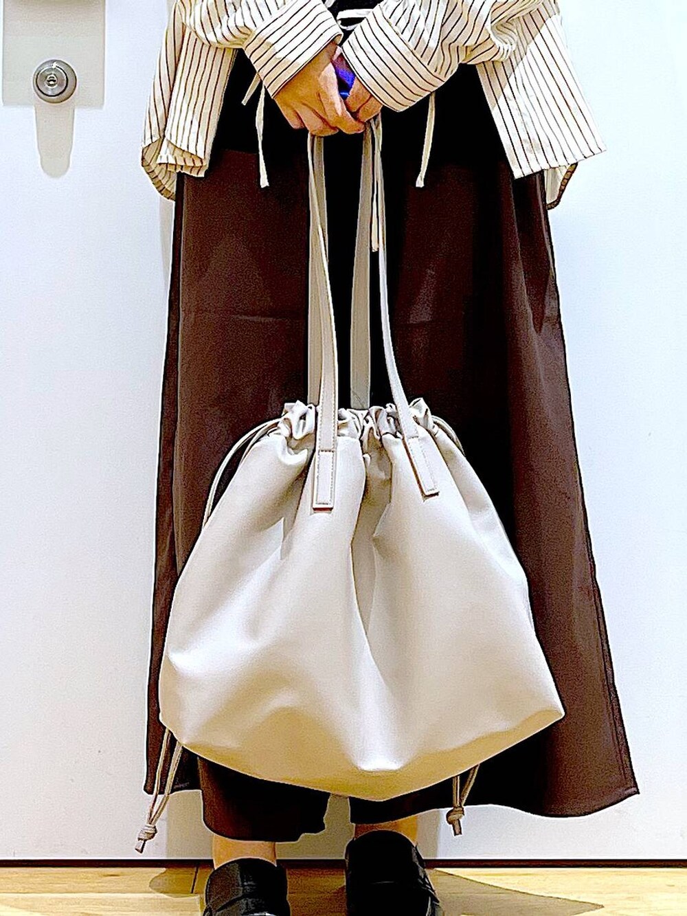 ベージュ系のトートバッグ、ブラック系のローファー、ブラウン系のその他パンツを着用したレディースの秋コーディネートの9枚目の写真