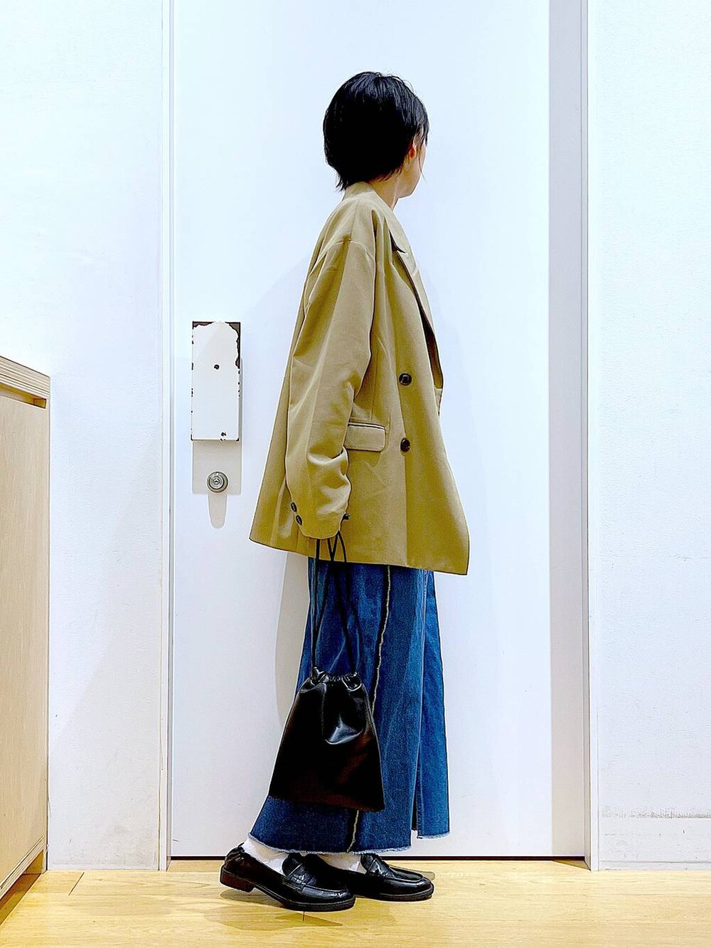 ブラック系のショルダーバッグ、ブラック系のローファー、ブラック系のTシャツ/カットソーを着用したレディースの秋コーディネートの4枚目の写真