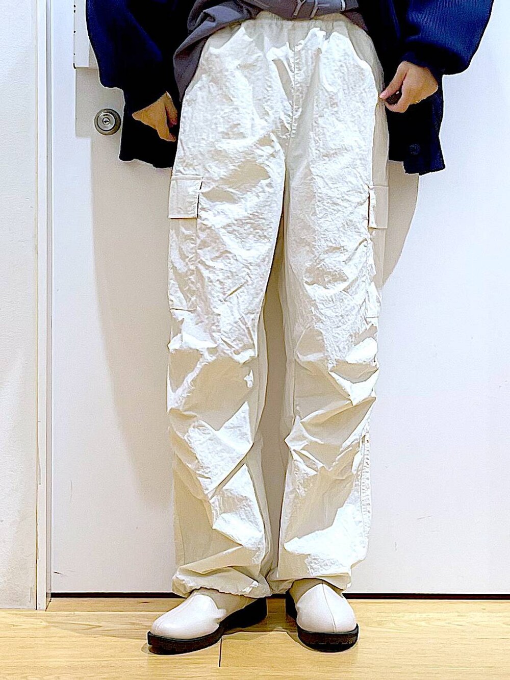 グレー系のTシャツ/カットソー、ベージュ系のブーツ、ホワイト系のショルダーバッグを着用したレディースの冬コーディネートの8枚目の写真