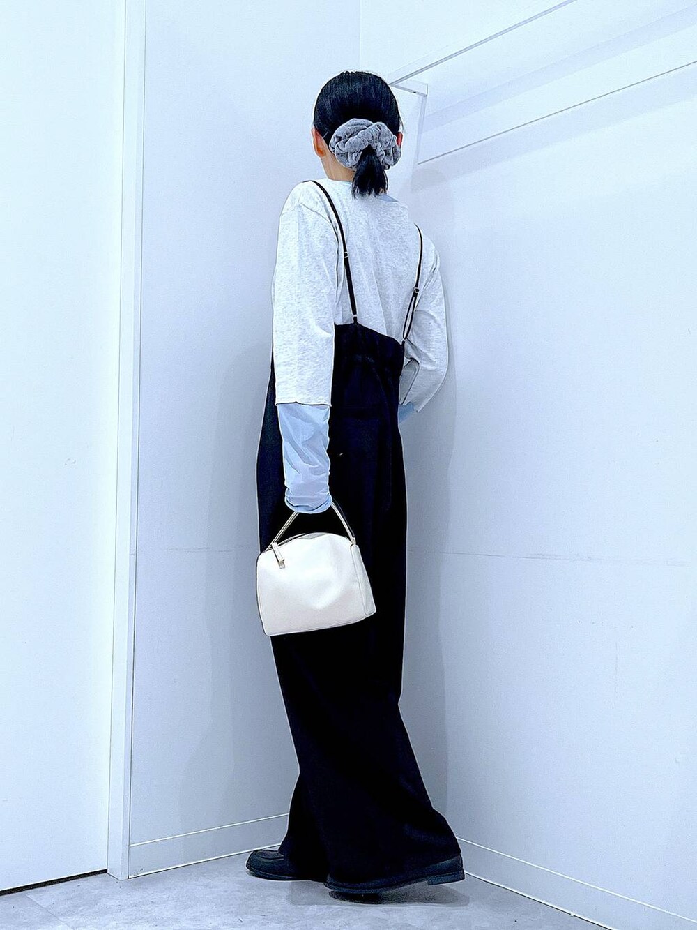 ホワイト系のショルダーバッグ、ブラック系のローファー、ブラック系のサロペット/オーバーオールを着用したレディースの春コーディネートの3枚目の写真