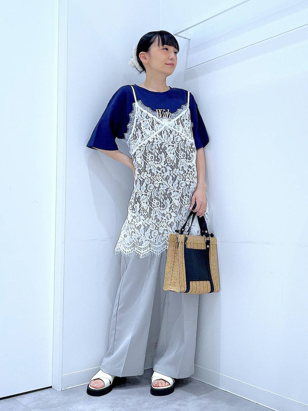 ベージュ系のショルダーバッグ、ホワイト系のサンダル、ブルー系のTシャツ/カットソーを着用したレディースの夏コーディネートの2枚目の写真