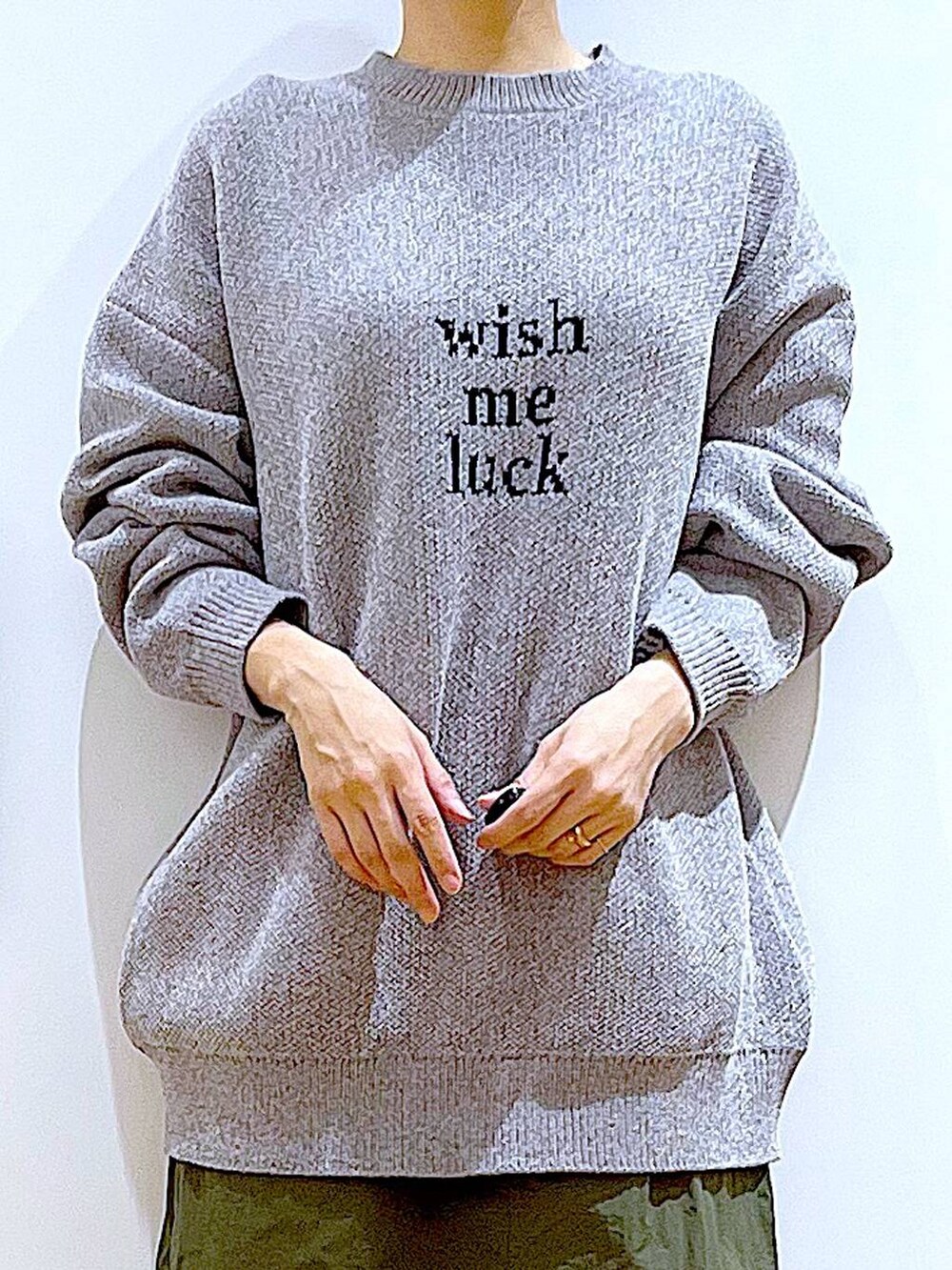 ブラック系のブーツ、グレー系のニット/セーター、グリーン系のスカートを着用したレディースの冬コーディネートの7枚目の写真