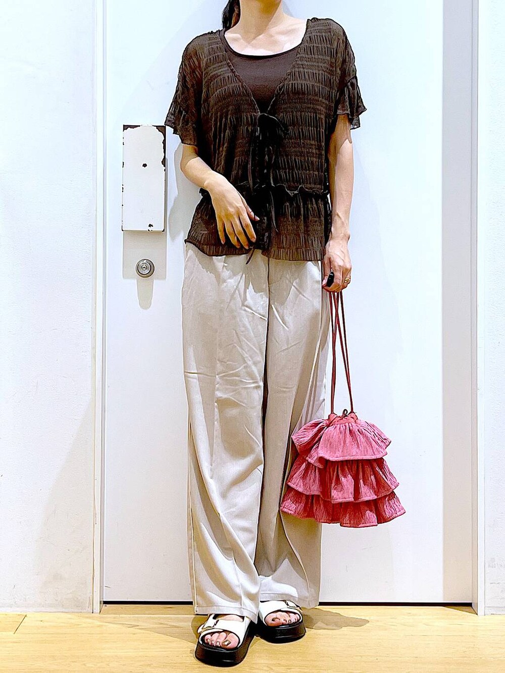 ホワイト系のサンダル、ベージュ系のスラックス、ピンク系のショルダーバッグを着用したレディースの秋コーディネートの6枚目の写真