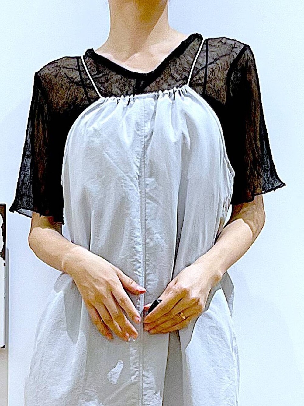 グレー系のワンピース、ホワイト系のショルダーバッグ、シルバー系のサンダルを着用したレディースの夏コーディネートの7枚目の写真