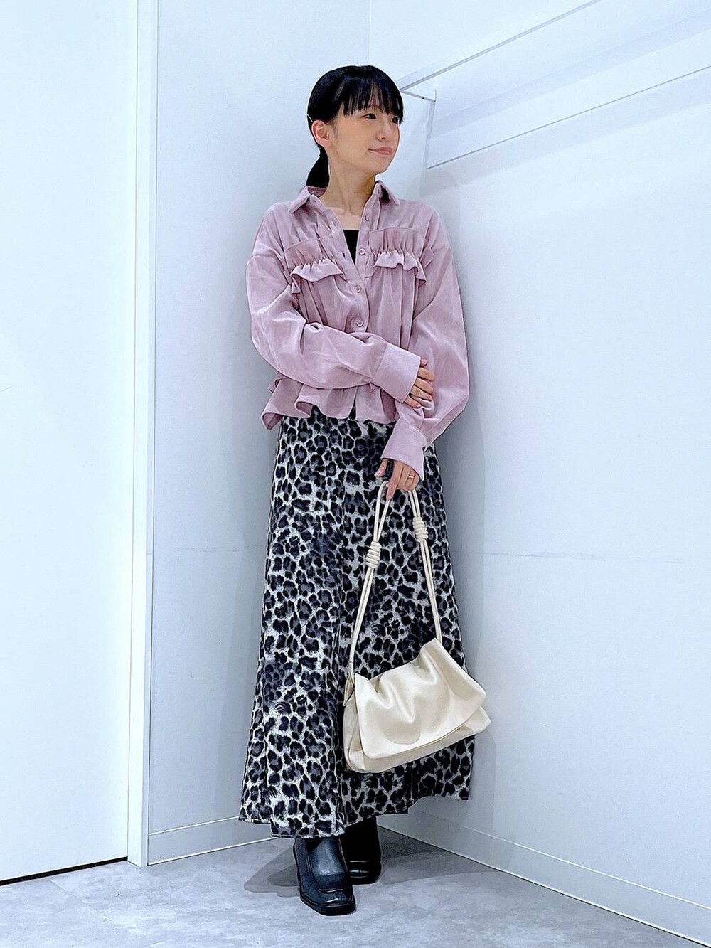 ホワイト系のショルダーバッグ、ブラック系のブーツ、グレー系のスカートを着用したレディースの秋コーディネートの2枚目の写真