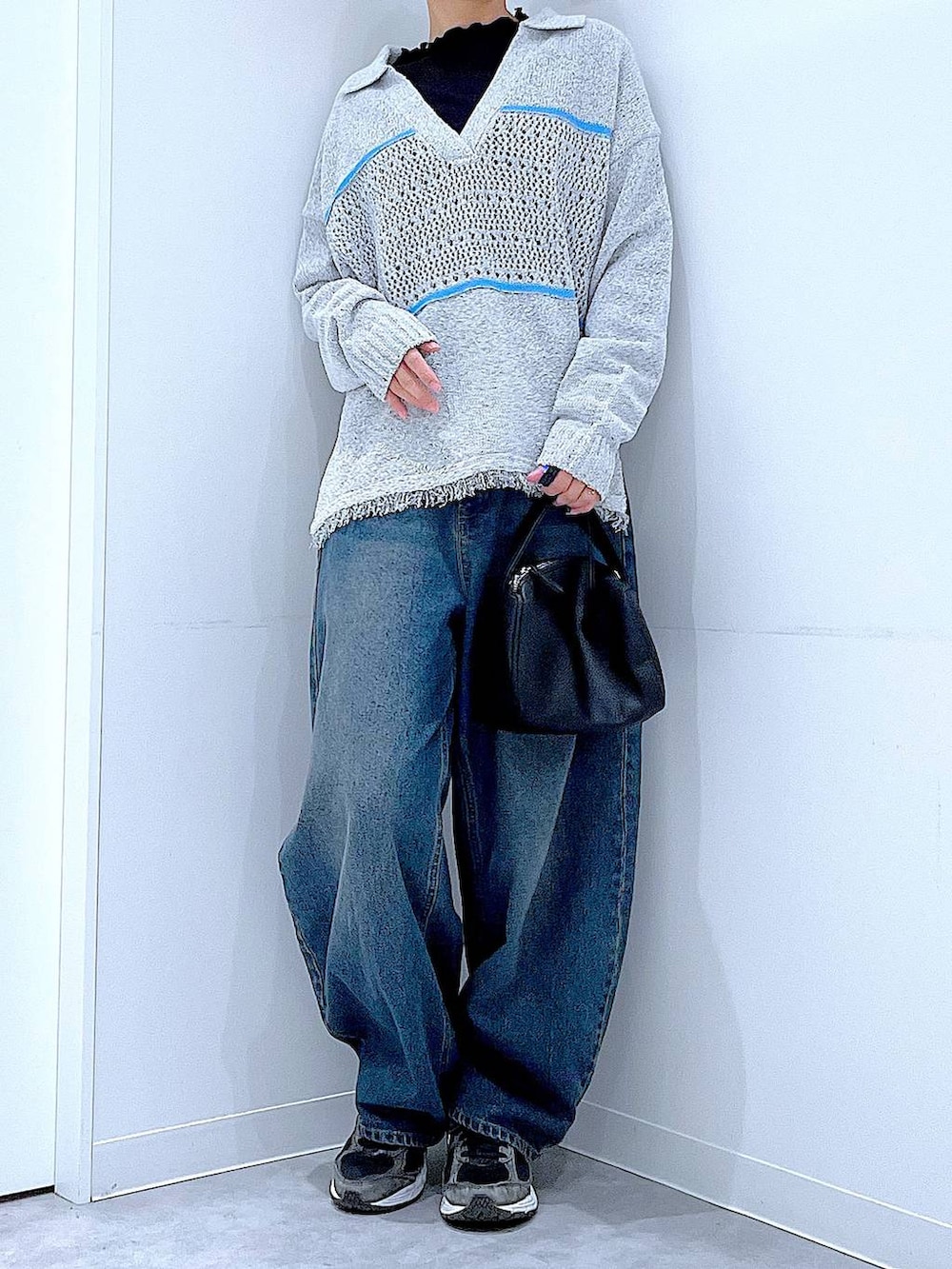 ブルー系のデニムパンツ、ブラック系のTシャツ/カットソー、ブラック系のショルダーバッグを着用したレディースの冬コーディネートの6枚目の写真