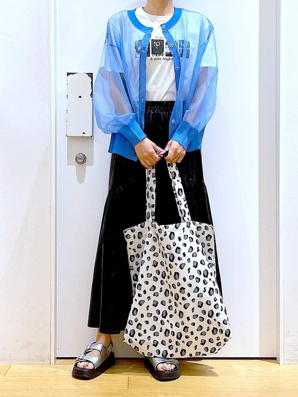 シルバー系のサンダル、ブルー系のカーディガン/ボレロ、ホワイト系のトートバッグを着用したレディースの夏コーディネートの6枚目の写真