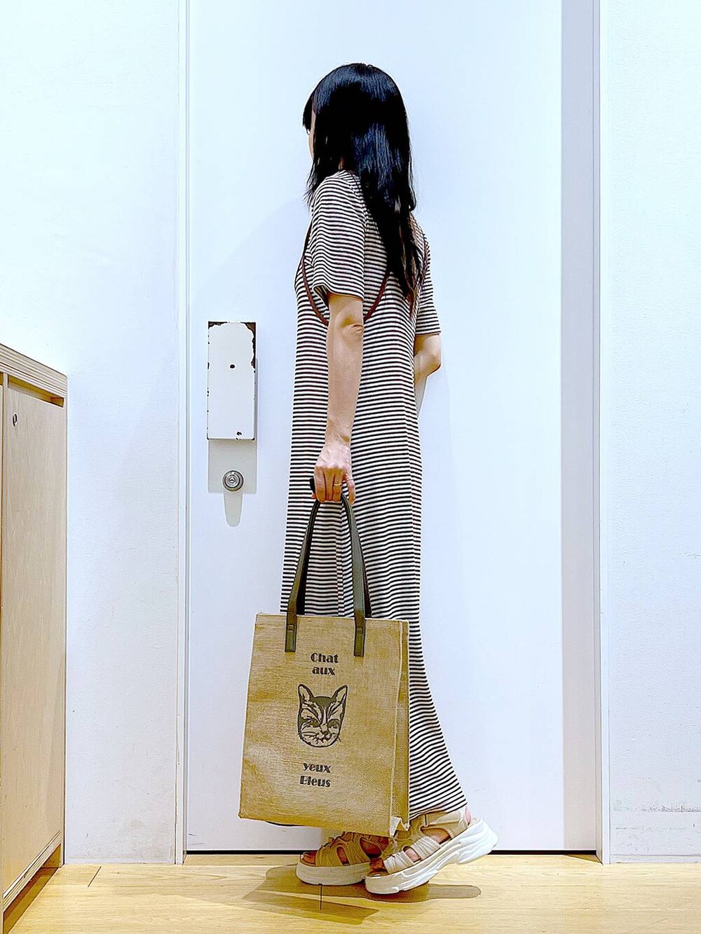 ベージュ系のサンダル、グレー系のトートバッグ、ベージュ系のワンピースを着用したレディースの夏コーディネートの3枚目の写真