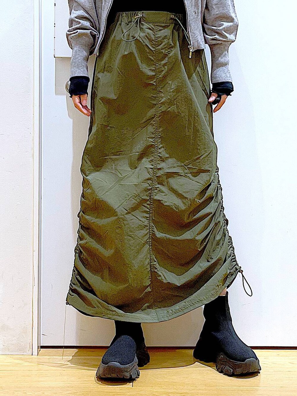 ブラック系のTシャツ/カットソー、グレー系のカーディガン/ボレロ、ブラック系のブーツを着用したレディースの冬コーディネートの8枚目の写真