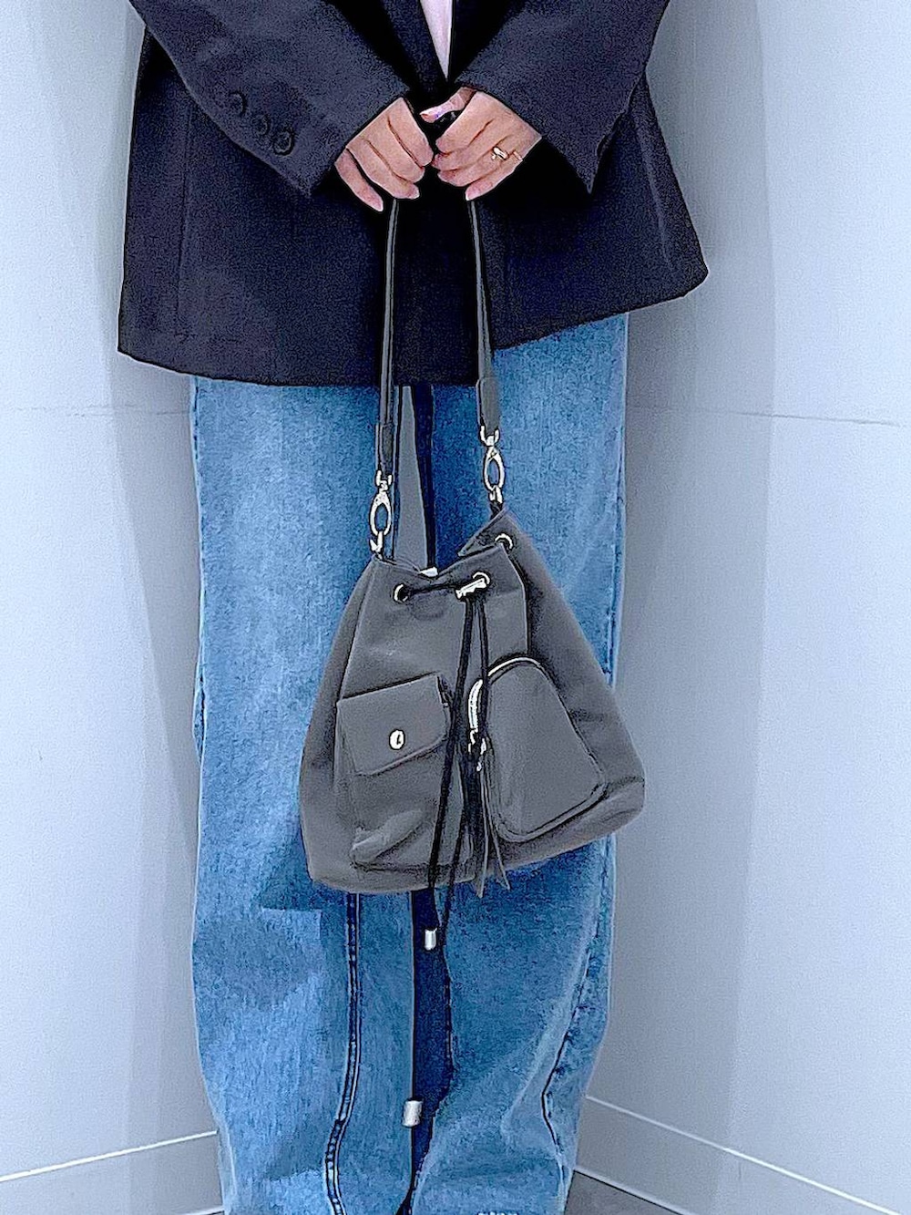 グレー系のテーラードジャケット、ブルー系のデニムパンツ、ピンク系のパーカーを着用したレディースの春コーディネートの9枚目の写真