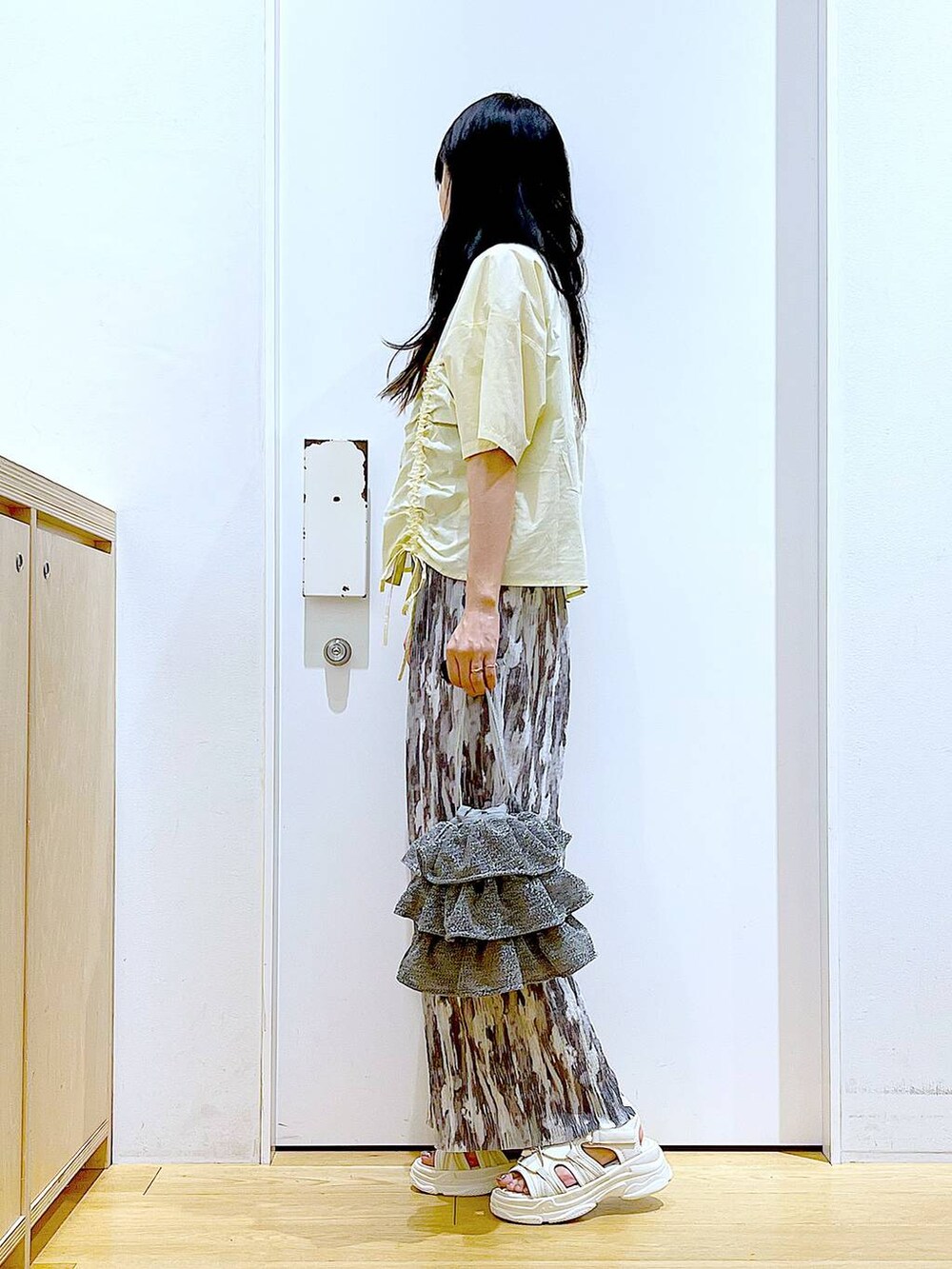 シルバー系のショルダーバッグ、ホワイト系のサンダル、グレー系のその他パンツを着用したレディースの春コーディネートの3枚目の写真