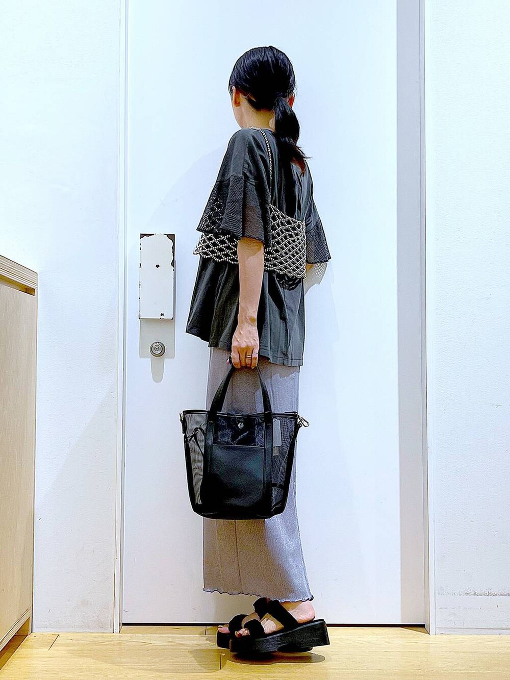 パープル系のスカート、ブラック系のサンダル、ブラック系のトートバッグを着用したレディースの夏コーディネートの3枚目の写真