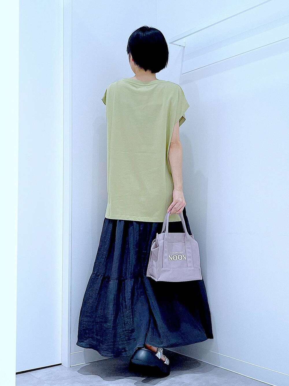 シルバー系のサンダル、グリーン系のTシャツ/カットソー、ブラック系のスカートを着用したレディースの夏コーディネートの5枚目の写真