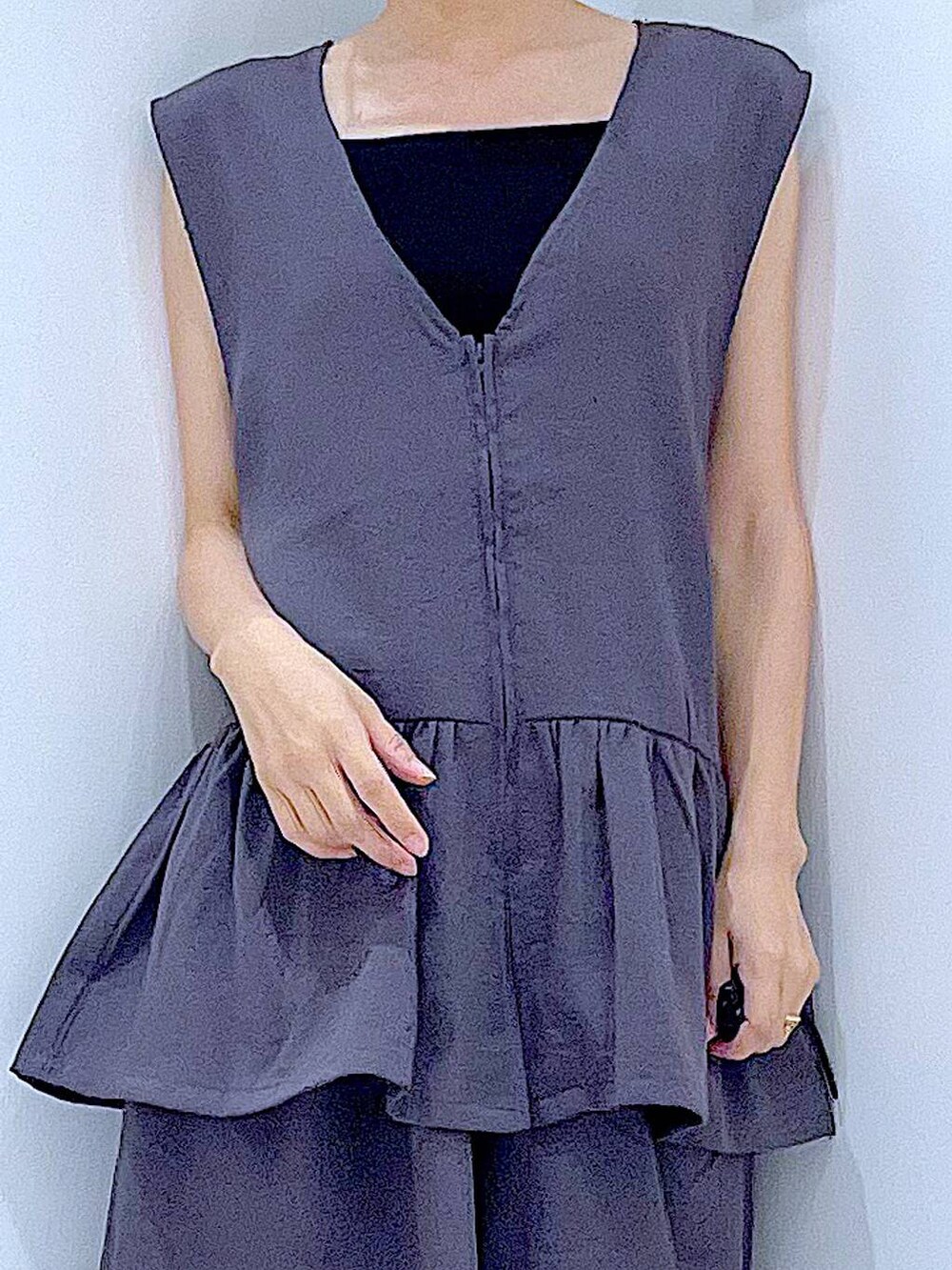 ブラック系のショルダーバッグ、ブラック系のサンダル、グレー系のベストを着用したレディースの夏コーディネートの7枚目の写真